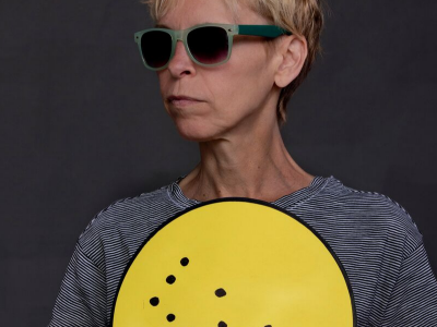 Alex Bulmer holding a yellow sign in Braille.