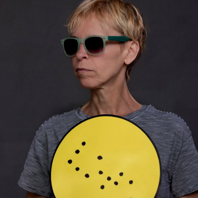 Alex Bulmer holding a yellow sign in Braille.