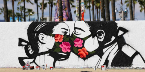 Graffiti image of couple kissing with face masks.