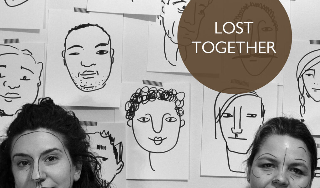 Poster for Lost Together. SHIRA LEUCHTER and MICHAELA WASHBURN stand in front of a wall postered with line drawing of faces. Sheila and Shira have lines drawn on their faces similar to the posters behind them.
