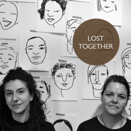 Poster for Lost Together. SHIRA LEUCHTER and MICHAELA WASHBURN stand in front of a wall postered with line drawing of faces. Sheila and Shira have lines drawn on their faces similar to the posters behind them.