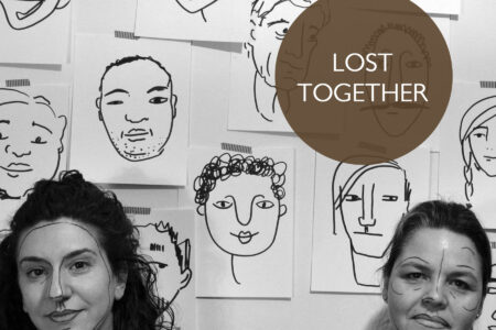 Poster for Lost Together. SHIRA LEUCHTER and MICHAELA WASHBURN stand in front of a wall postered with line drawing of faces. Sheila and Shira have lines drawn on their faces similar to the posters behind them.