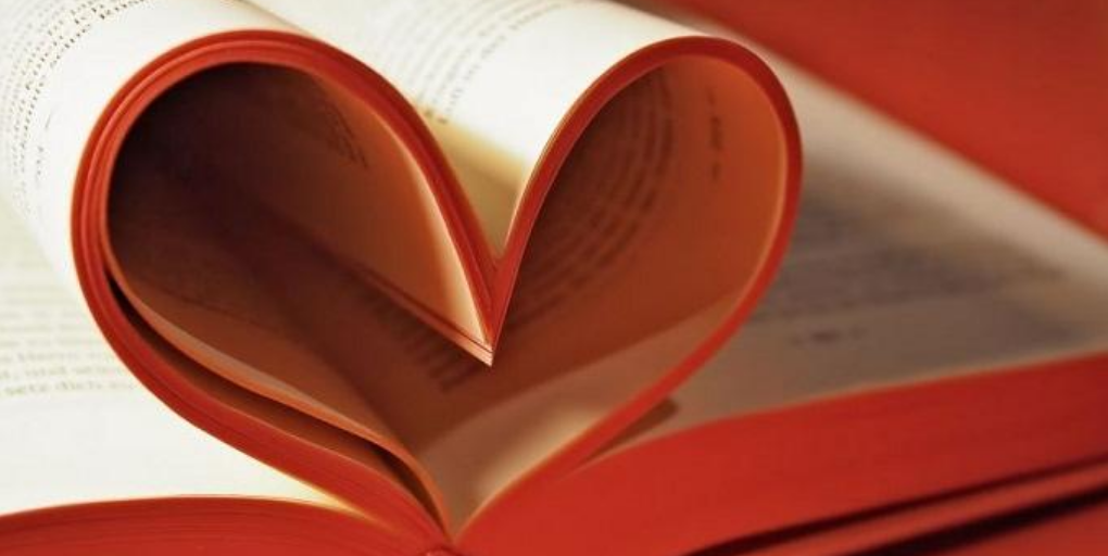 A book with pages curled to make a heart shape.