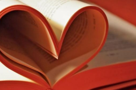 A book with pages curled to make a heart shape.