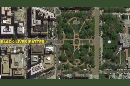 Aerial view of a city, with "Black Lives Matter" written in yellow paint on the street.