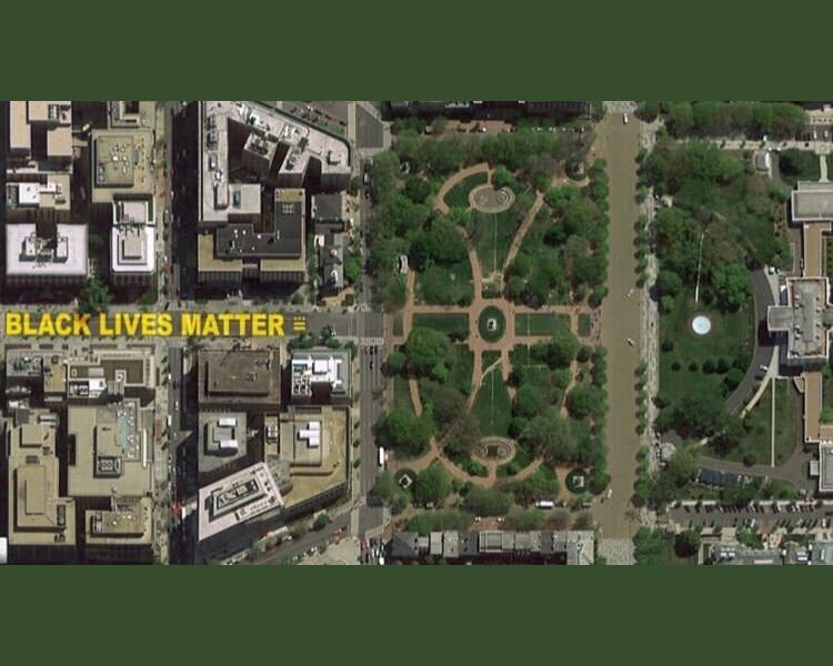 Aerial view of a city, with "Black Lives Matter" written in yellow paint on the street.