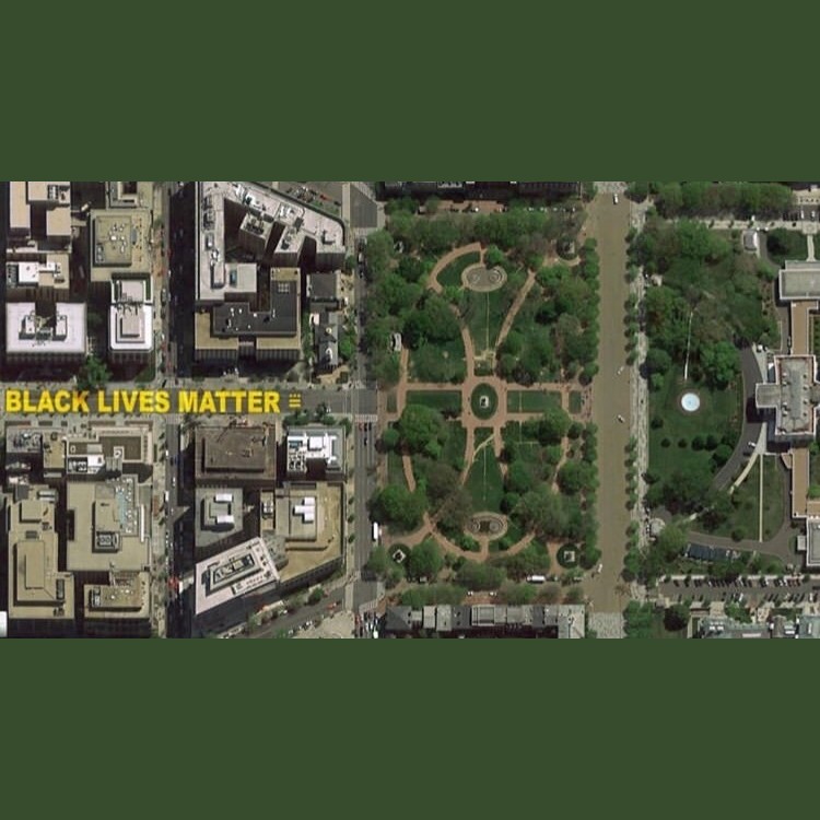 Aerial view of a city, with "Black Lives Matter" written in yellow paint on the street.