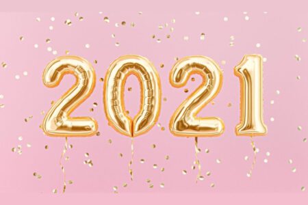 Gold 2021 balloons on a pink background.
