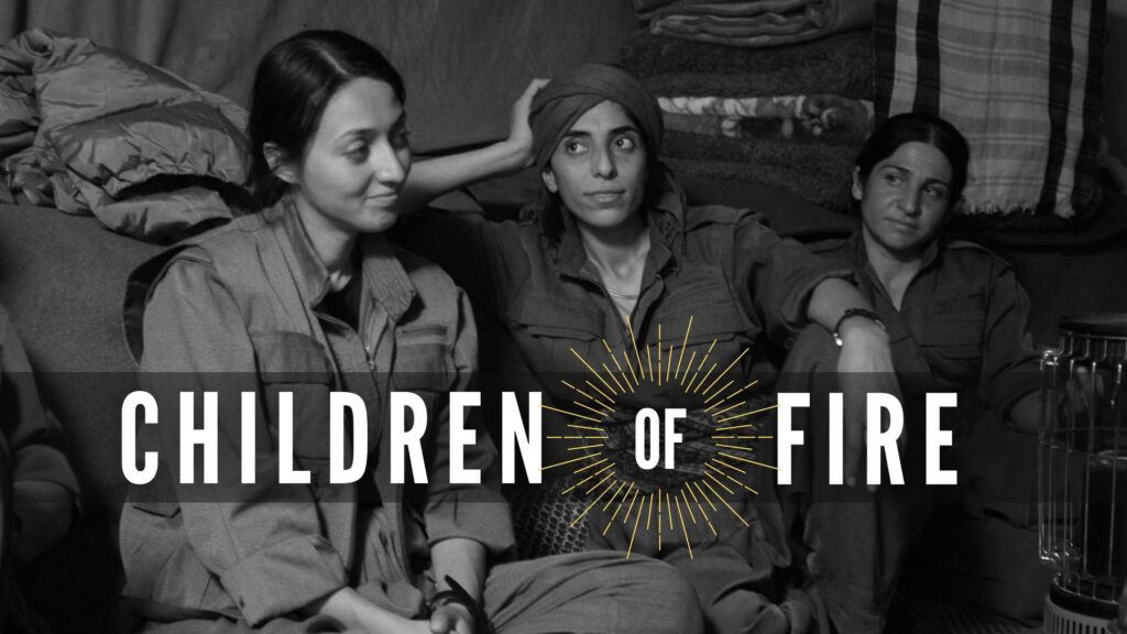 Three female Kurdish Freedom Fighters sit side by side inside a shelter. The one to the far left has a gentle smile. In white, the words Children of Fire is at the lower third of the image. There are beams of light around the "of" in the title that harken to the sun on the Kurdish flag.