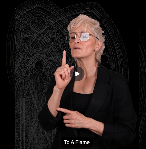 ASL video thumbnail for To a Flame showing a person in glasses and a black blazer signing in front of a dark gothic arch background.
